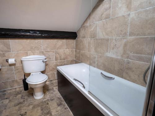 a bathroom with a toilet and a bath tub at The Black Boy Inn in Caernarfon