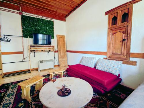 a living room with a red couch and a table at National Monument Konak in Stolac