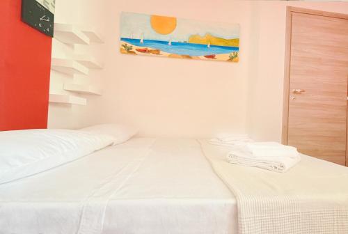 a white room with a bed and a painting on the wall at Da Elisa MareSol in Quartu SantʼElena