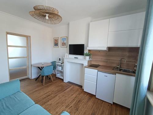 a kitchen with a couch and a table in a room at Escapade Béthunoise in Béthune