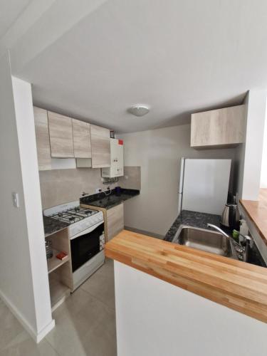a small kitchen with a sink and a stove at Agradable departamento in Cordoba