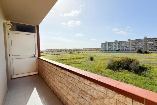 a balcony with a door and a view of a field at Da Elisa MareSol in Quartu SantʼElena