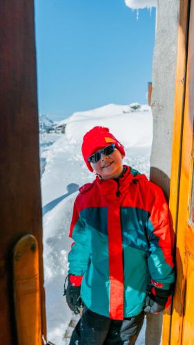 a man standing in the snow next to a building at Hotel Spa Nieves Del Cerro in Caviahue