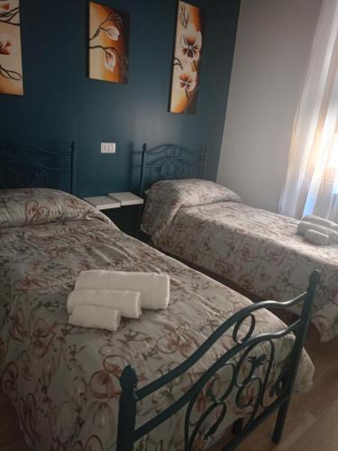 two beds in a room with towels on the bed at Gevihome in Capua