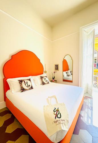 a bedroom with a large bed with an orange headboard at Voglia 'e turnà in Naples