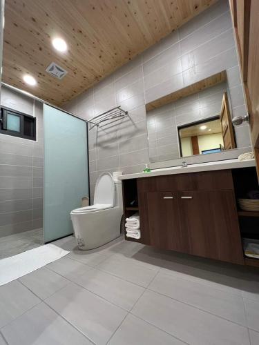 a bathroom with a toilet and a sink and a mirror at 宣信民宿 標準雙人房 in Le-yeh
