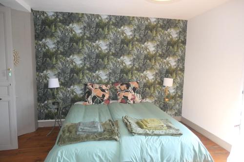 a bedroom with a green bed with a wallpaper at Chambres d'Hôtes Colibri in Arthez-de-Béarn