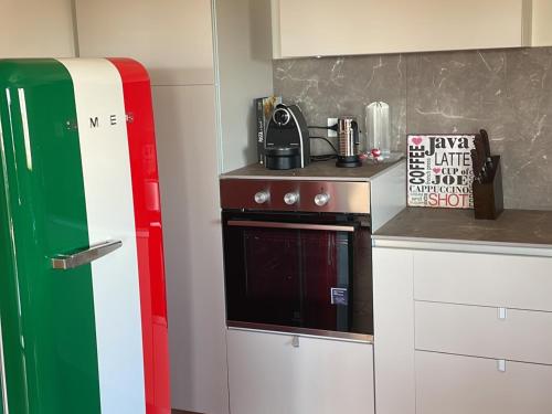 una cocina con un horno rojo blanco y verde. en Ferienwohnung Dolce Vita Toskana - Massa Marittima mit Parkplatz, Bikeferien meernah, en Massa Marittima