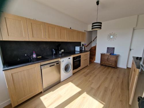 Il comprend une cuisine équipée d'un lave-linge, d'un évier et d'un lave-vaisselle. dans l'établissement Maison de ville à saint coulomb, à Saint-Coulomb