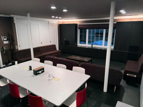 a meeting room with a white table and chairs at BIEI TERRACE 1st Floor - 1F専用独立玄関 - 1F占有78平米大型ワンルーム- ソファベッド7台, 170型米Valerion社製最新シアター動画視聴, 無料Wi-Fi, シャワー, ミニキッチン付き - 駅前通り沿い - in Biei