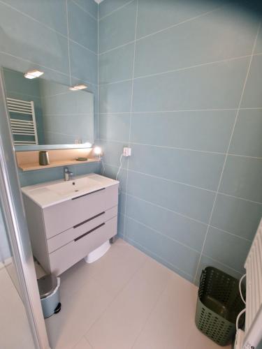 a bathroom with a sink and a mirror at Maison de ville à saint coulomb in Saint-Coulomb