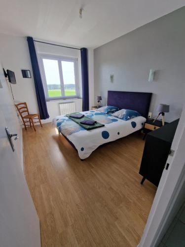 a bedroom with a bed and a large window at Maison de ville à saint coulomb in Saint-Coulomb