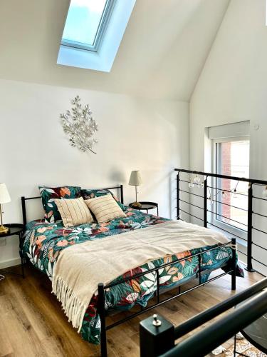 une chambre avec un lit et une lucarne dans l'établissement Superbe loft - Le Petit Galibot, à Vimy