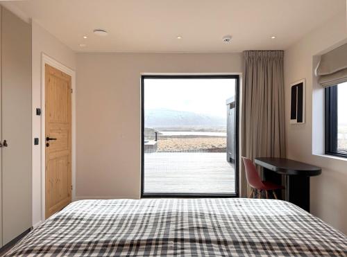 a bedroom with a bed and a large window at Bakkar luxury lodge in Minni-Borg