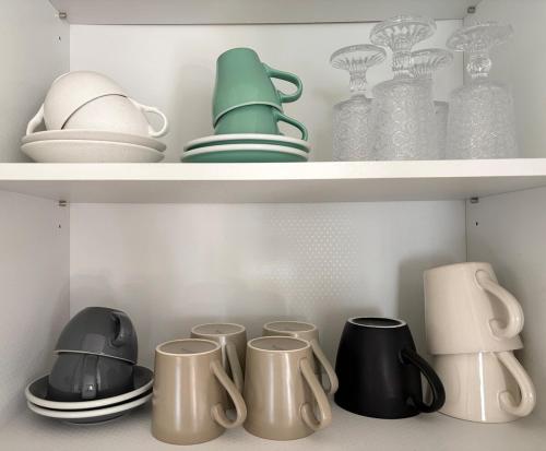 ein Regal mit Tellern, Tassen und anderen Küchenutensilien in der Unterkunft Yeondam Stay in Seoul