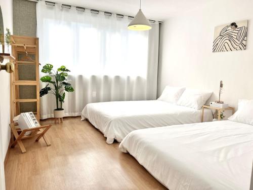 ein Schlafzimmer mit zwei Betten und einem Fenster in der Unterkunft Yeondam Stay in Seoul