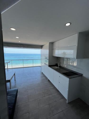 eine Küche mit weißen Schränken und Meerblick in der Unterkunft 1st line La Fossa Luxury Beach Apartment *ADULTS ONLY* in Calpe