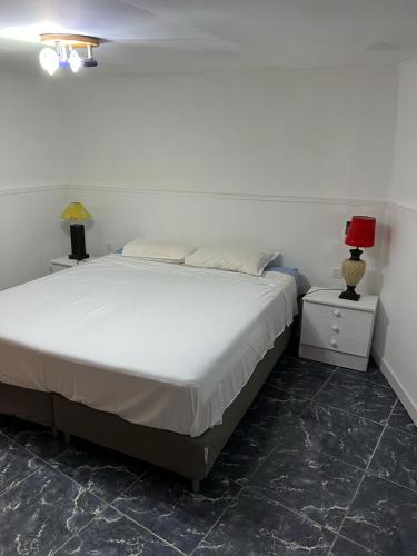 a bedroom with a bed and two night stands with lamps at Claudia - Gortito in Playa Paraiso