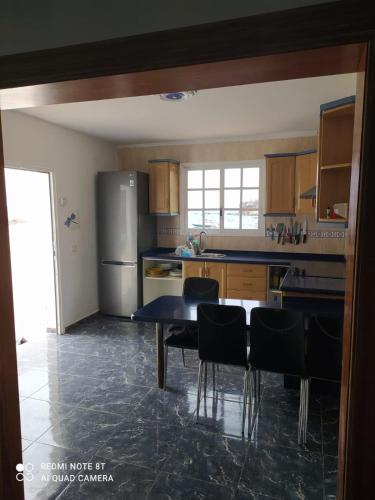 a kitchen with a table and chairs and a refrigerator at Claudia - Gortito in Playa Paraiso
