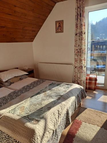 a bedroom with two beds and a window at Pensiunea Pitic in Cheia