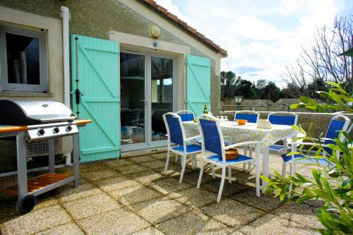 un patio avec une table, des chaises et un barbecue dans l'établissement Ardèche Horizon, Appartement climatisé avec Terrasse, Piscine et Parking, à Vallon-Pont-dʼArc