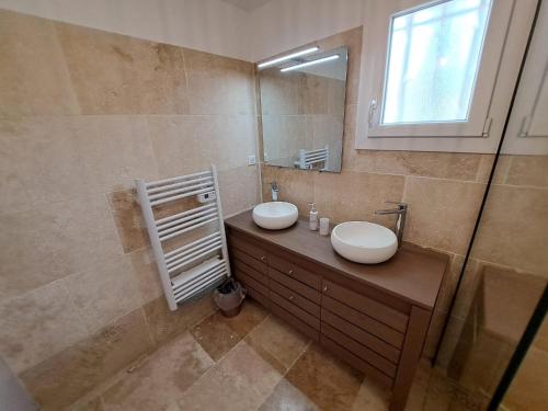 une salle de bain avec un lavabo et un miroir dans l'établissement Villa cosy, à Six-Fours-les-Plages