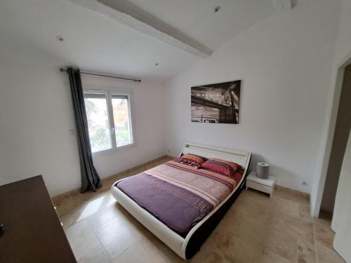 une chambre avec un lit dans une pièce avec une fenêtre dans l'établissement Villa cosy, à Six-Fours-les-Plages