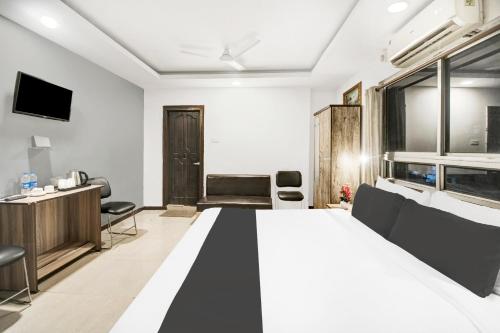 a hotel room with a large bed and a desk at Townhouse Hatigaon Near Medicity Formerly Hotel Grand Majesty in Guwahati