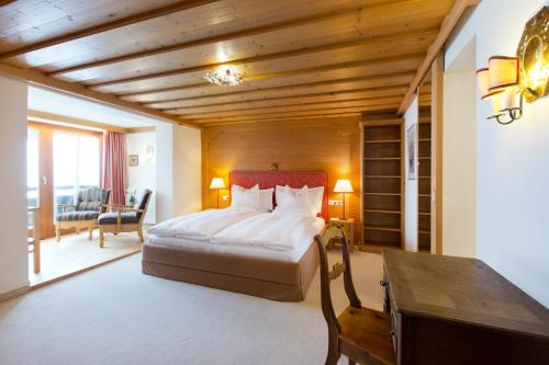 a bedroom with a bed and a desk in a room at Hotel Angela in Lech am Arlberg
