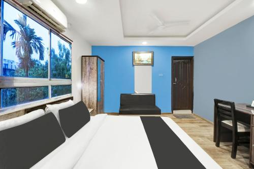 a bedroom with a bed and a blue wall at Townhouse Hatigaon Near Medicity Formerly Hotel Grand Majesty in Guwahati