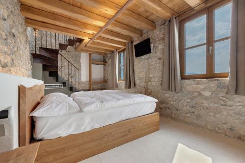 a bedroom with a large bed in a stone wall at Casa Limonaia al Pos in Tignale