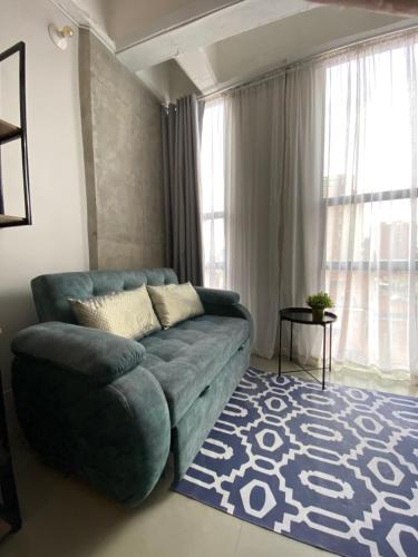 a living room with a blue couch and a rug at Apartamento Central Bogota in Bogotá