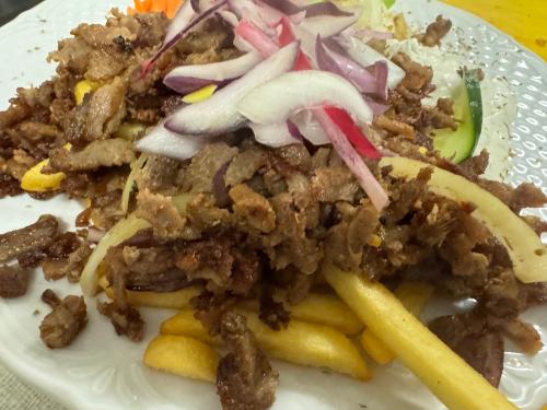 a plate of food with meat and french fries at Alpen Hotel Martin in Nesselwang