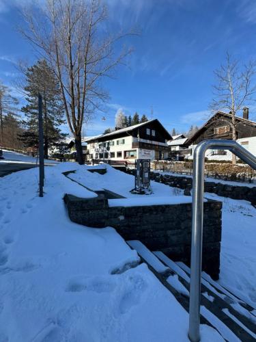 a snow covered park with a gate in the snow at Alpen Hotel Martin in Nesselwang