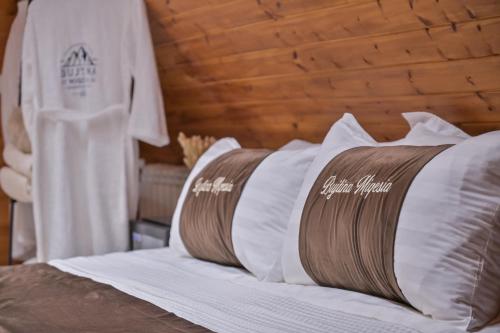 a bed with white pillows on top of it at Bujtina Miqesia in Theth