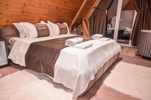 a bedroom with a large bed with two phones on it at Bujtina Miqesia in Theth