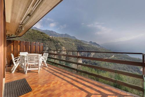 a balcony with white chairs and a view of the mountains at Appartamento Annarosa, Piovere in Piovere