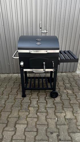 a charcoal grill sitting next to a wall at Ferienwohnung Föhrenweg in Neumarkt in der Oberpfalz
