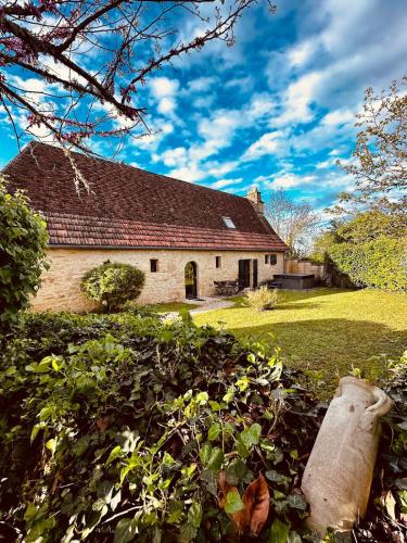 une maison ancienne avec un toit sur une cour verdoyante dans l'établissement Le Logis de Saint-Chamassy, à Saint-Chamassy