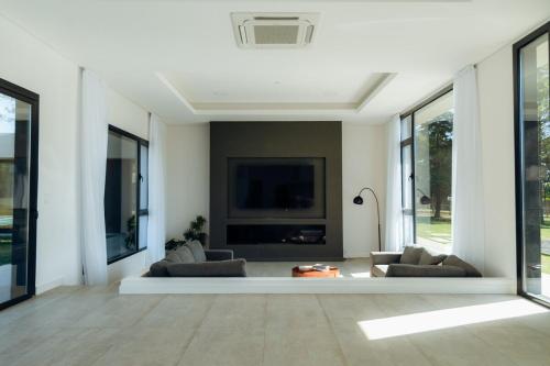 Una sala de estar con dos sofás y un televisor de pantalla plana. en Lujosa casa en barrio privado, en Ciudad de la Costa