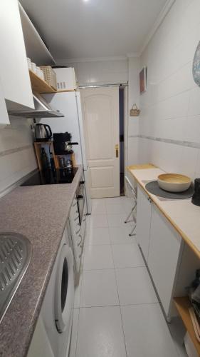 a small white kitchen with a washer and dryer at Brisa Marina in Mogro