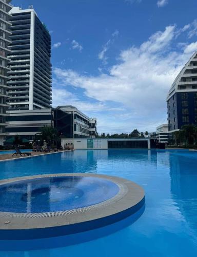 a large swimming pool with buildings in the background at Luxury Suites White Sails in Batumi