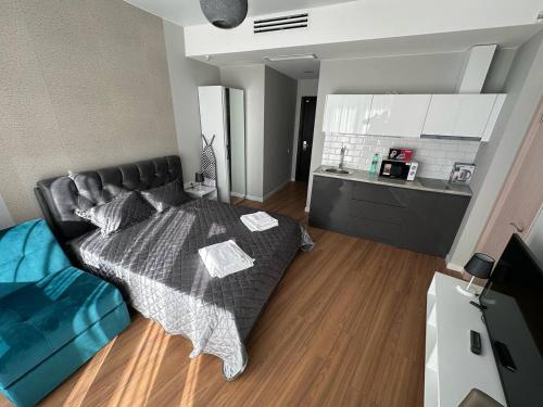 a living room with a bed and a kitchen at Luxury Suites White Sails in Batumi