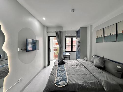a bedroom with a bed and a tv on the wall at The Little Hanoi - Cool Apartment - Lakeside in Hanoi