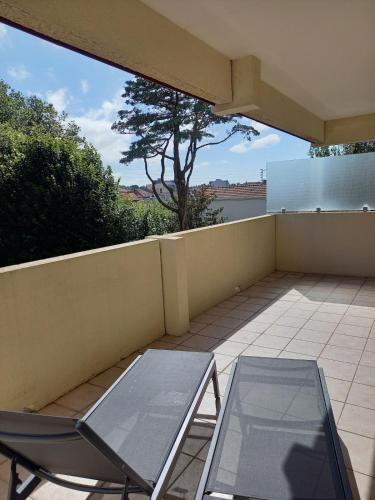 une terrasse avec une table en verre et une chaise dans l'établissement Charmant appartement bord de mer, à Arcachon