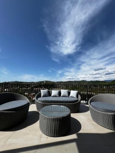 a patio with wicker chairs and couches on a balcony at Rioni & Bagrati Panorama in Kutaisi