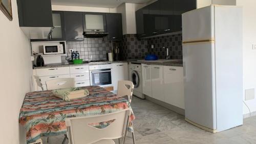 a kitchen with a table and chairs and a refrigerator at appt cosy , front de mer in Hammam Sousse