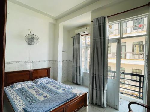 une chambre avec un lit et une grande fenêtre dans l'établissement Nhà Nghỉ Hải Đăng, à Quy Nhơn