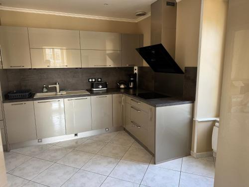 a kitchen with white cabinets and a sink at Village Collection Le Vauvert in Ormoy-la-Rivière