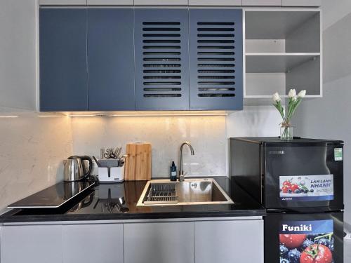 a kitchen with blue cabinets and a sink at The Little Hanoi - Cool Apartment - Lakeside in Hanoi